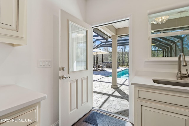 doorway to outside with a sink and a sunroom