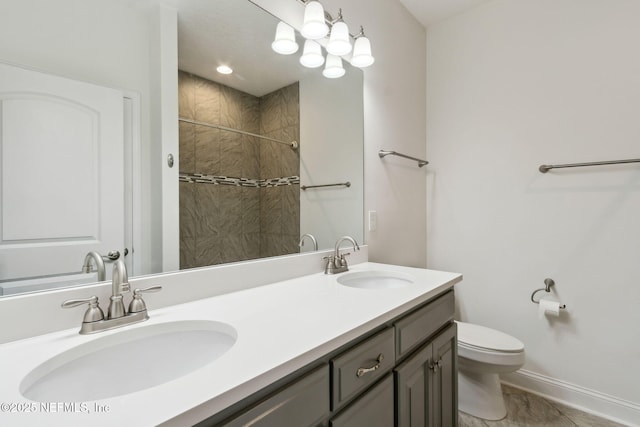 bathroom featuring double vanity, a sink, toilet, and baseboards