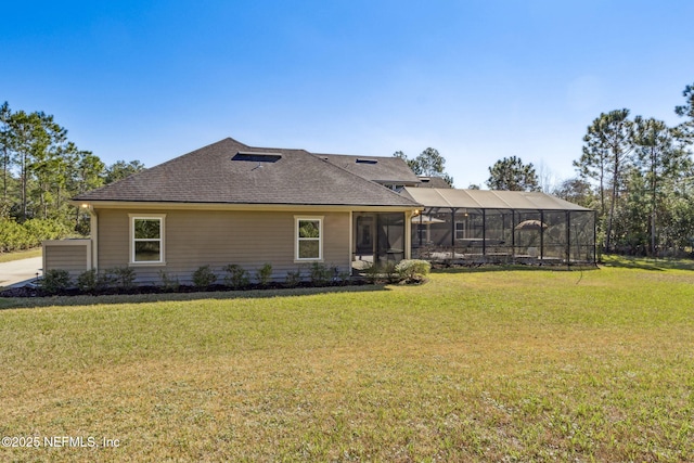 rear view of property with glass enclosure, a lawn, and roof with shingles