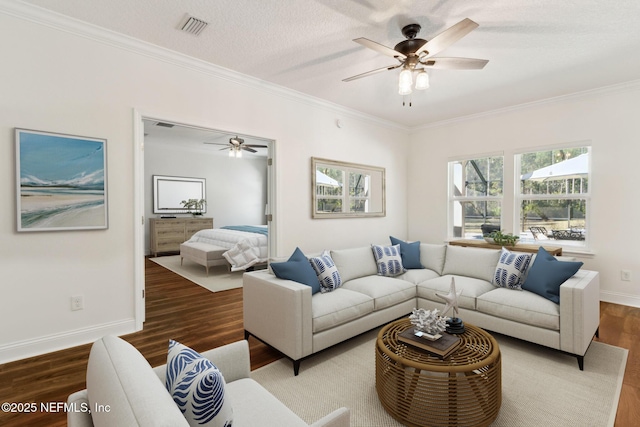 living area featuring ornamental molding, visible vents, baseboards, and wood finished floors