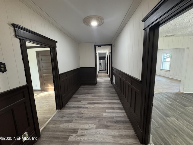 corridor featuring ornamental molding and wood-type flooring