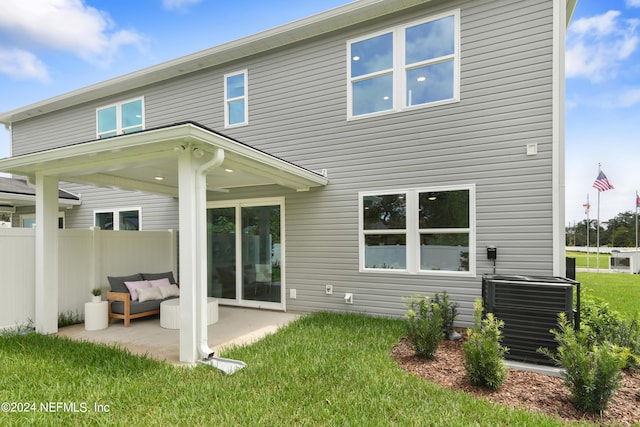 back of house with a patio, a lawn, and central air condition unit