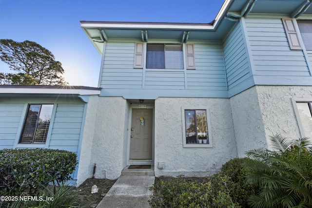 property entrance featuring stucco siding