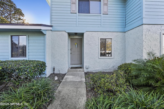 doorway to property with stucco siding