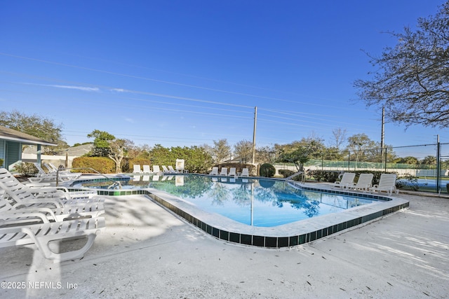 community pool featuring a patio area and fence