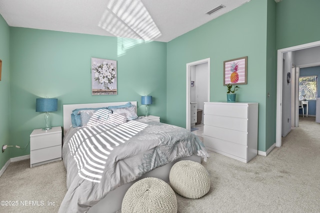 carpeted bedroom featuring baseboards, visible vents, and ensuite bathroom