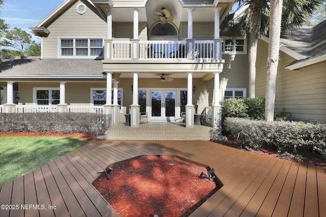 back of property with ceiling fan, a porch, a balcony, a shingled roof, and french doors