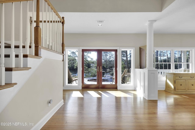 doorway with visible vents, stairway, french doors, light wood-type flooring, and ornate columns