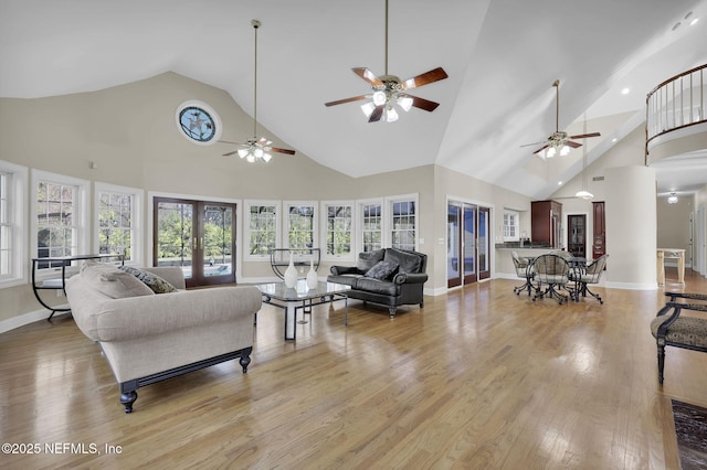 living area featuring high vaulted ceiling, french doors, light wood-style flooring, and baseboards