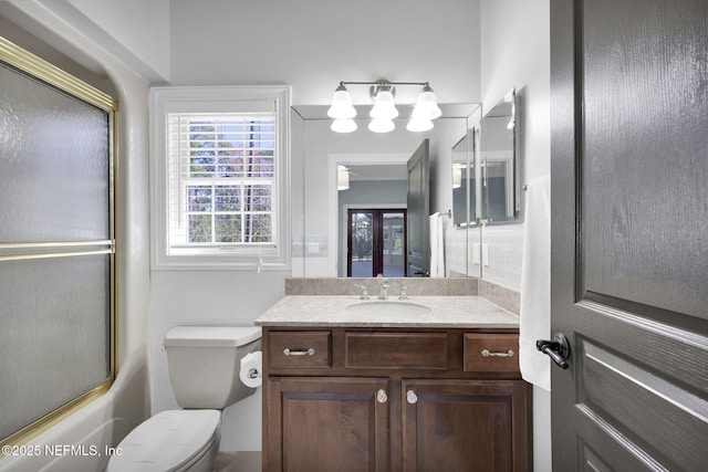 bathroom featuring combined bath / shower with glass door, vanity, and toilet