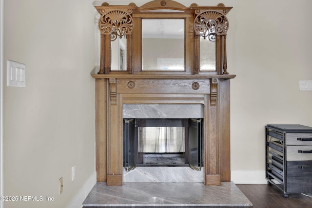 room details featuring a fireplace, wood finished floors, and baseboards