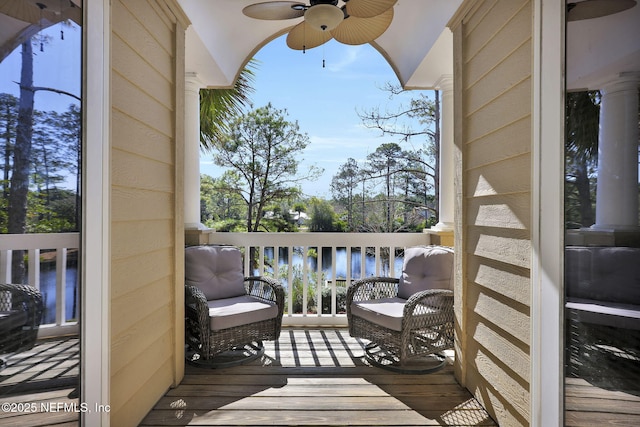 wooden deck featuring a ceiling fan and a water view