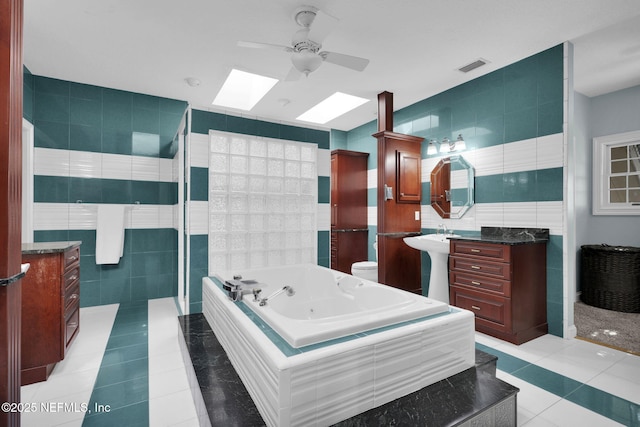 full bath featuring toilet, tile walls, vanity, and tile patterned floors