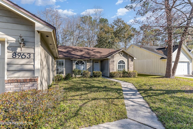 exterior space with a yard, brick siding, and a garage