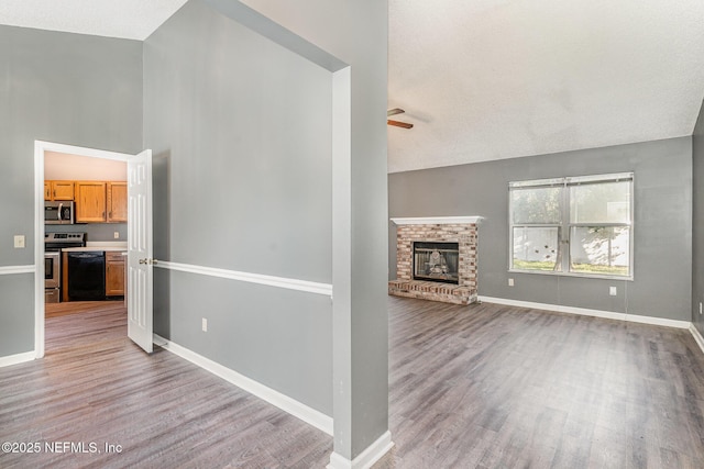 unfurnished living room featuring ceiling fan, baseboards, and wood finished floors