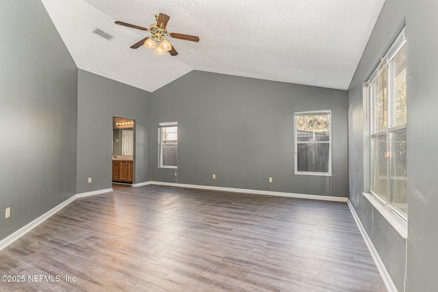 unfurnished room with visible vents, wood finished floors, lofted ceiling, and ceiling fan