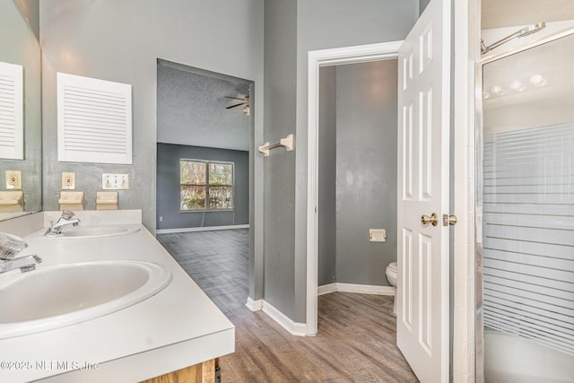 full bath with a sink, wood finished floors, toilet, and ceiling fan