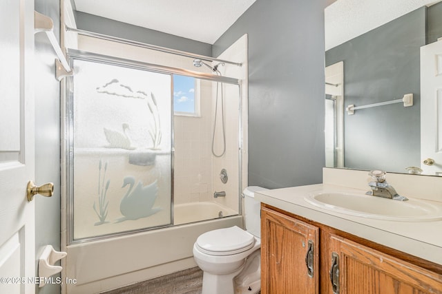 bathroom featuring bath / shower combo with glass door, toilet, and vanity