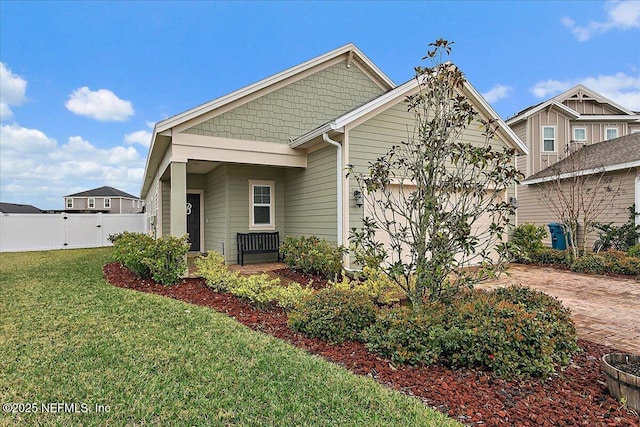 view of front facade featuring a garage, driveway, fence, and a front lawn