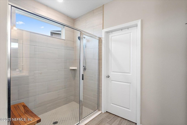 bathroom featuring a shower stall and wood finished floors