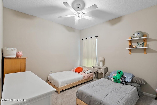 bedroom with a textured ceiling, carpet floors, a ceiling fan, and baseboards