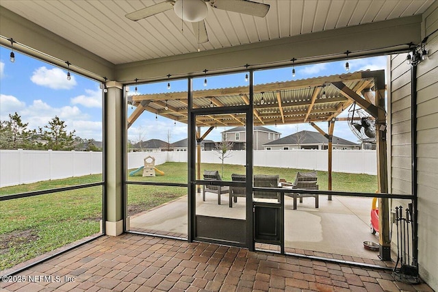 unfurnished sunroom featuring a ceiling fan