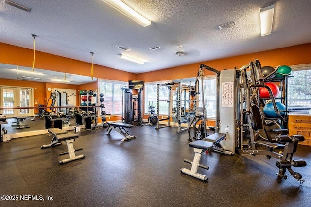 workout area featuring a textured ceiling and french doors