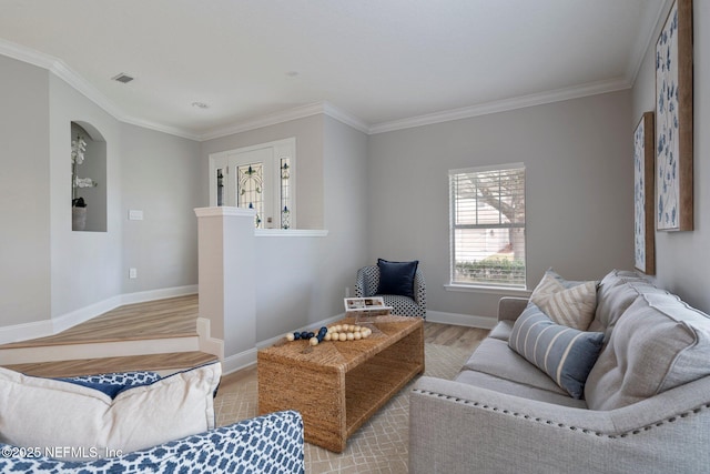 living room with light wood-style flooring, crown molding, visible vents, and baseboards