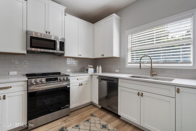 kitchen with tasteful backsplash, appliances with stainless steel finishes, and a sink