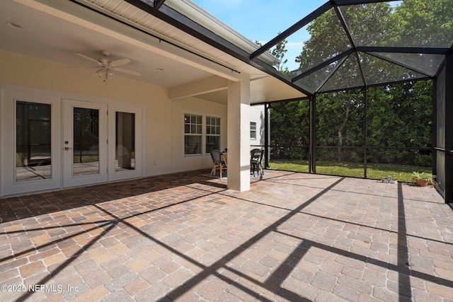 view of patio featuring ceiling fan, glass enclosure, and french doors