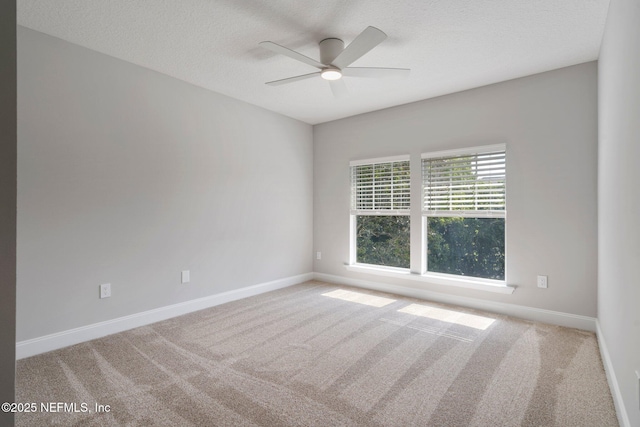 empty room featuring a textured ceiling, carpet floors, and baseboards