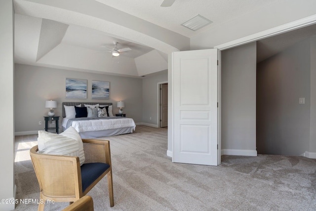 bedroom with a raised ceiling, light colored carpet, visible vents, a ceiling fan, and baseboards