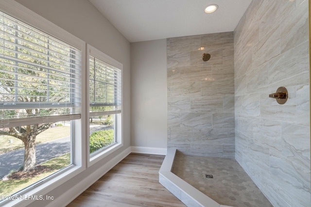 full bath with baseboards, a tile shower, wood finished floors, and recessed lighting