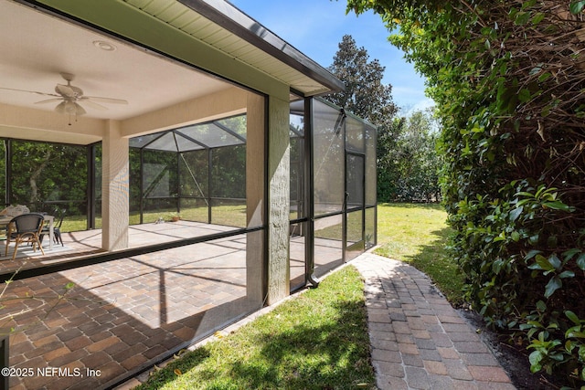 view of patio with glass enclosure and a ceiling fan