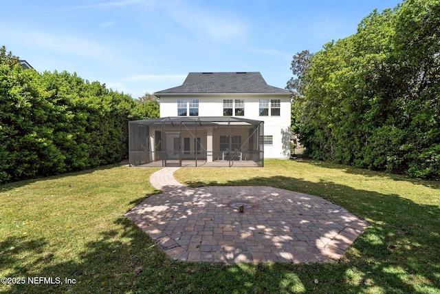 rear view of house featuring glass enclosure, a patio area, and a lawn