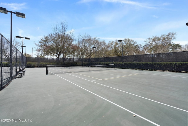 view of tennis court featuring fence