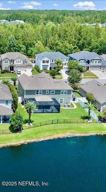 birds eye view of property featuring a water view, a forest view, and a residential view