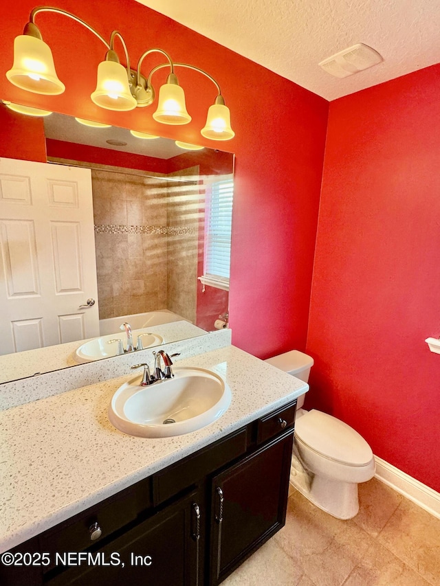 bathroom with a textured ceiling, toilet, visible vents, vanity, and baseboards