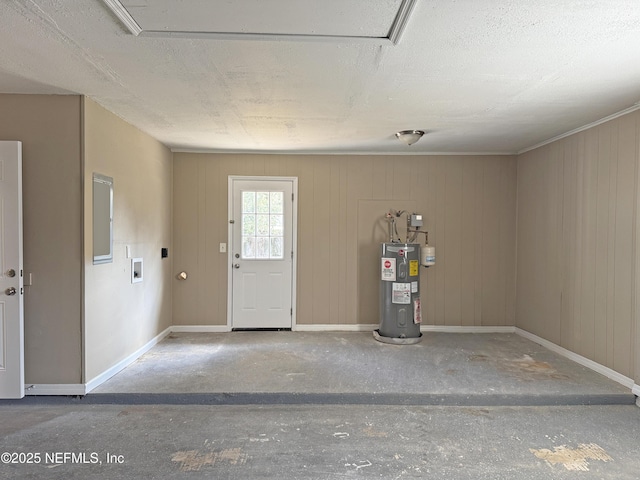 garage featuring baseboards and electric water heater