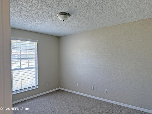 unfurnished room with a textured ceiling, a textured wall, carpet floors, and baseboards