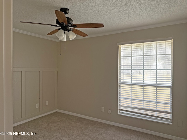 spare room featuring ornamental molding, light colored carpet, ceiling fan, and a textured ceiling