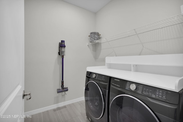 laundry room with laundry area, baseboards, and separate washer and dryer