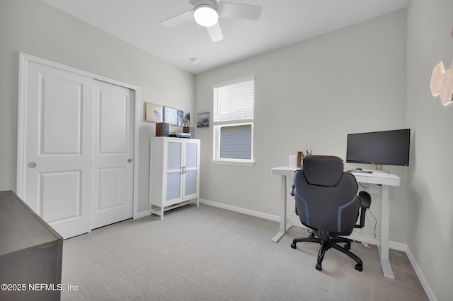 carpeted office with ceiling fan and baseboards