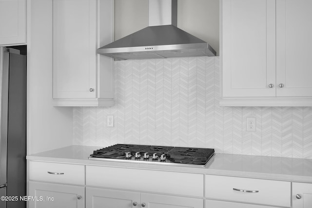 kitchen with wall chimney exhaust hood, appliances with stainless steel finishes, light countertops, and white cabinetry