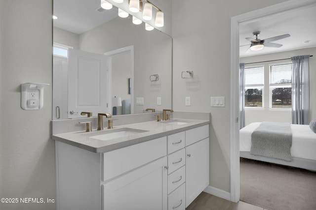 bathroom featuring double vanity, a ceiling fan, a sink, and ensuite bathroom