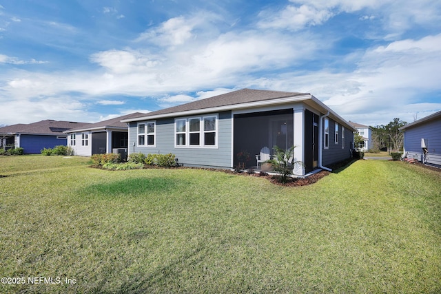 back of house featuring a sunroom and a lawn