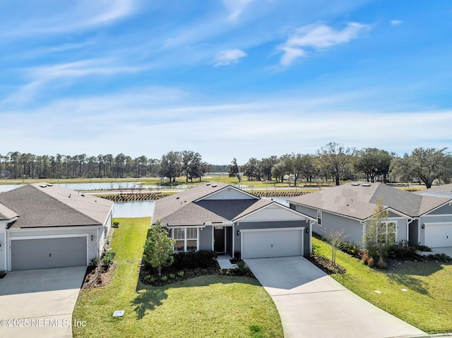 ranch-style home featuring a front yard, concrete driveway, a water view, and an attached garage