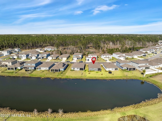 birds eye view of property featuring a water view, a residential view, and a view of trees