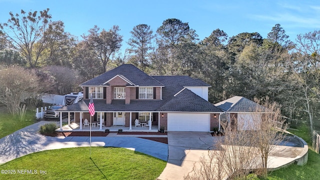 view of front facade with covered porch, a front lawn, and a garage