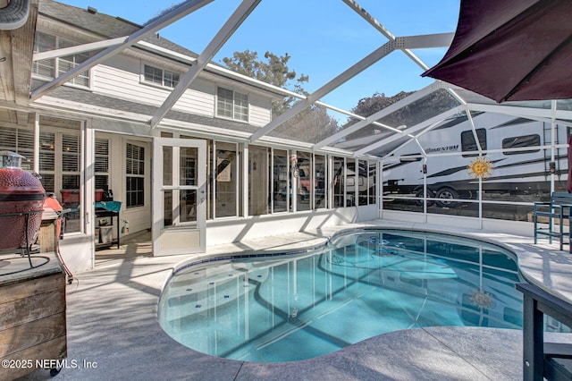 view of swimming pool featuring a patio area and a lanai